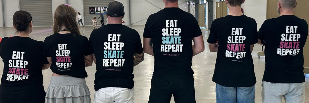 Group of people wearing black t-shirts with 'Eat Sleep Skate Repeat' text in a public indoor setting.